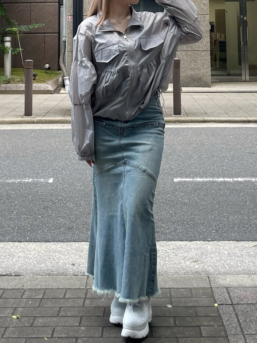 グレー系のパーカー、ブルー系のデニムスカートを着用したレディースの夏コーディネートの2枚目の写真