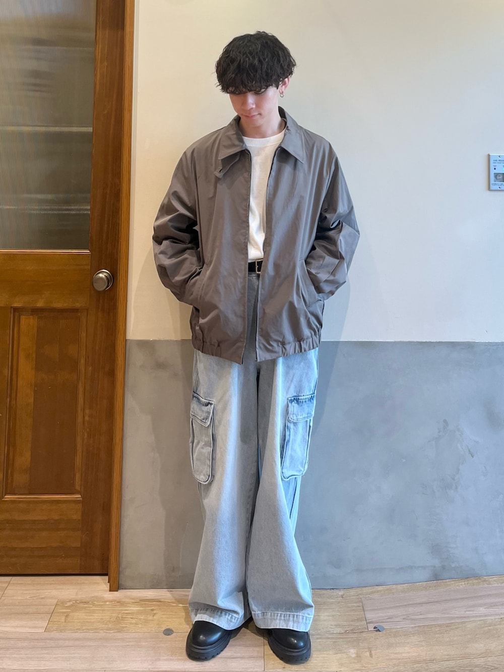 グリーン系のブルゾン、ホワイト系のTシャツ/カットソー、ブルー系のカーゴパンツを着用したメンズの春コーディネートの2枚目の写真