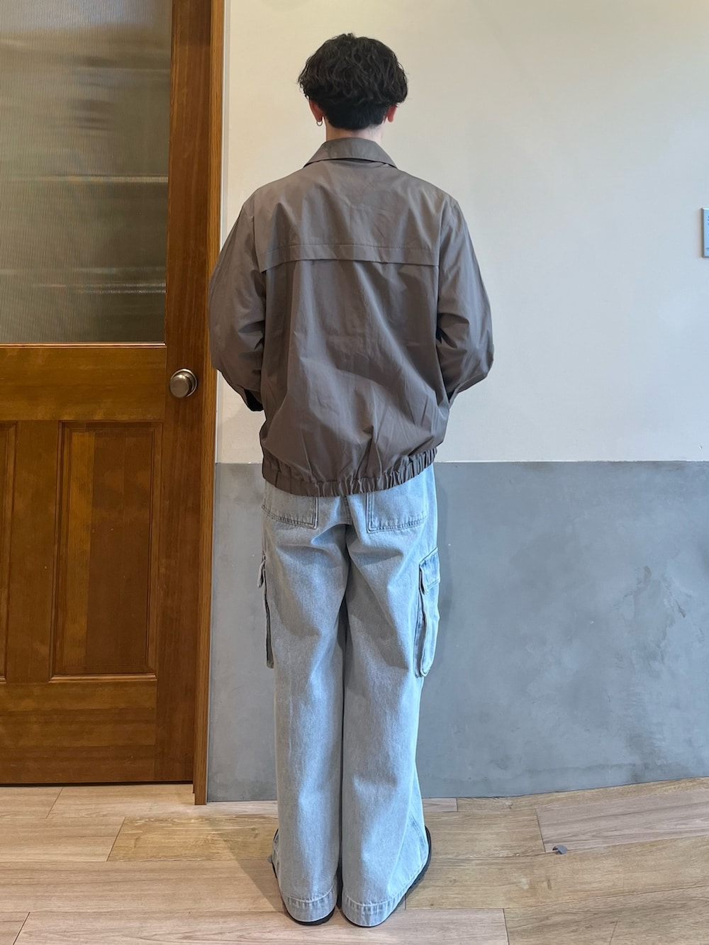 グリーン系のブルゾン、ホワイト系のTシャツ/カットソー、ブルー系のカーゴパンツを着用したメンズの春コーディネートの6枚目の写真