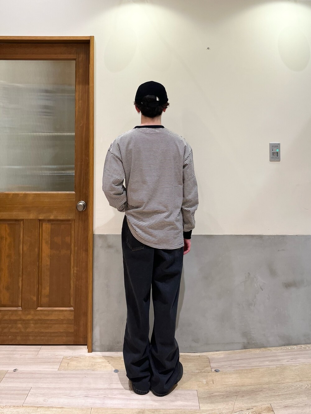 ブラック系のデニムパンツ、ブラック系のTシャツ/カットソー、ブラック系のキャップを着用したメンズの春コーディネートの3枚目の写真