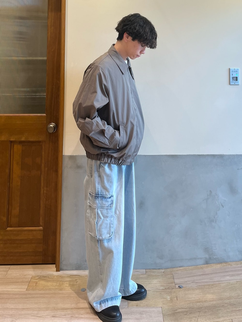 グリーン系のブルゾン、ホワイト系のTシャツ/カットソー、ブルー系のカーゴパンツを着用したメンズの春コーディネートの5枚目の写真