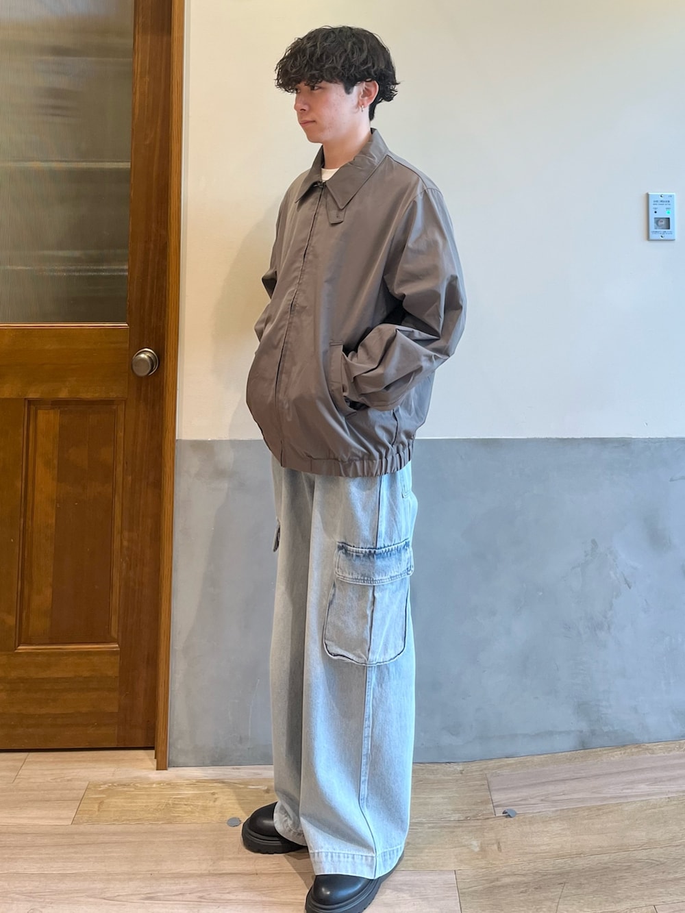 グリーン系のブルゾン、ホワイト系のTシャツ/カットソー、ブルー系のカーゴパンツを着用したメンズの春コーディネートの4枚目の写真