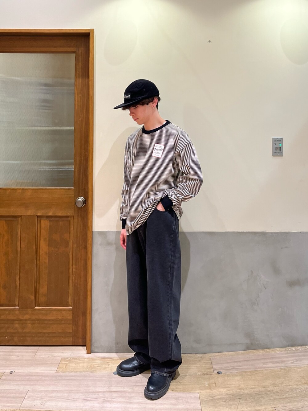 ブラック系のデニムパンツ、ブラック系のTシャツ/カットソー、ブラック系のキャップを着用したメンズの春コーディネートの2枚目の写真