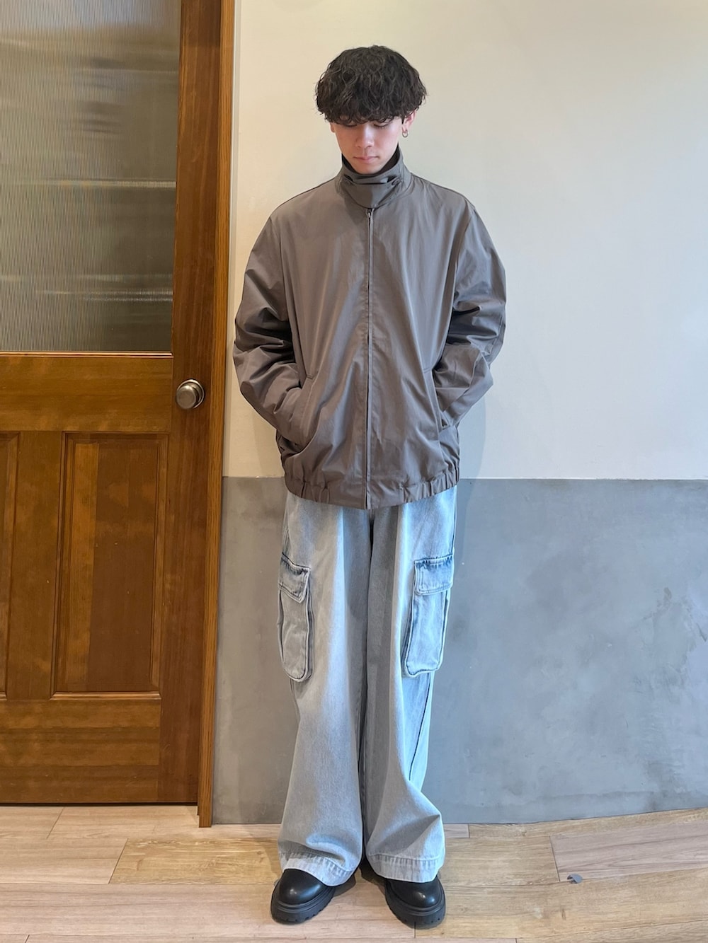 グリーン系のブルゾン、ホワイト系のTシャツ/カットソー、ブルー系のカーゴパンツを着用したメンズの春コーディネートの3枚目の写真