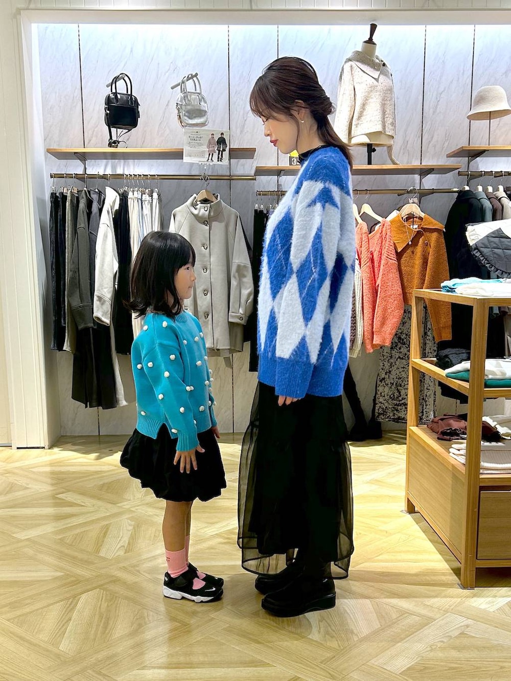 ブルー系のニット/セーター、ブラック系のブーツ、ブルー系のニット/セーターを着用したレディースの秋コーディネートの2枚目の写真