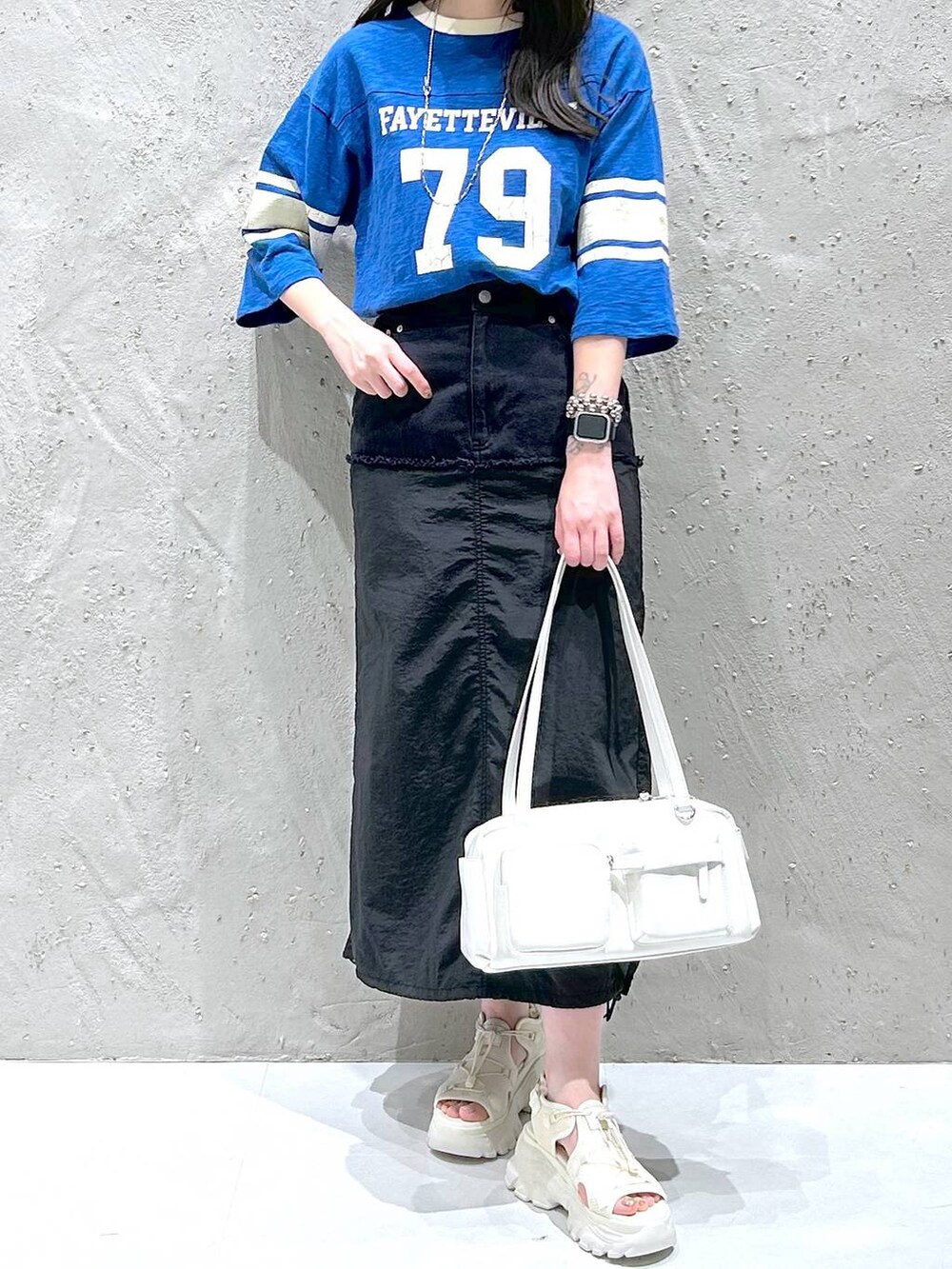 ホワイト系のサンダル、ブラック系のデニムスカート、ホワイト系のボストンバッグを着用したレディースの夏コーディネートの3枚目の写真