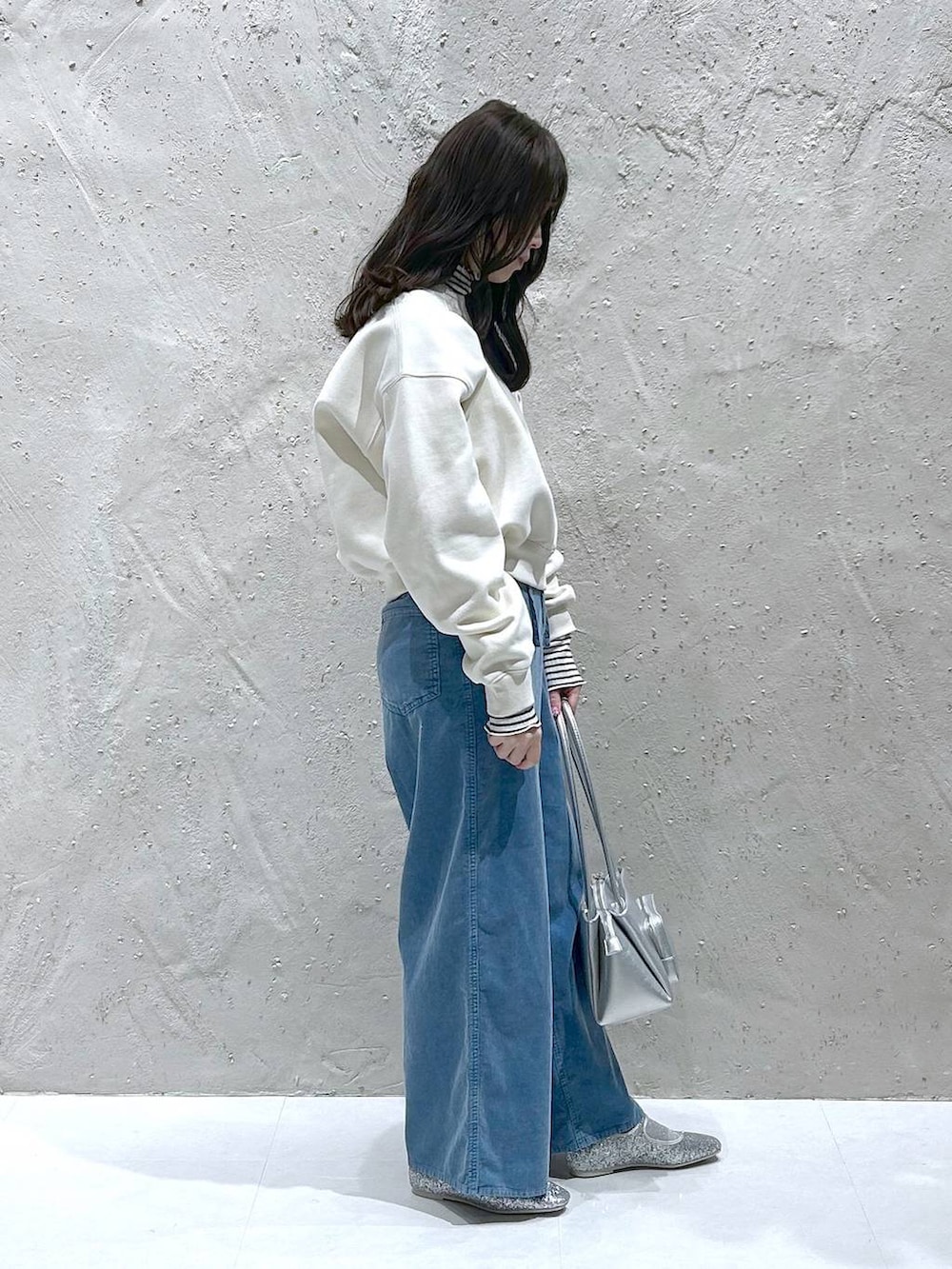 シルバー系のバレエシューズ、シルバー系のショルダーバッグ、ホワイト系のスウェットを着用したレディースの冬コーディネートの3枚目の写真