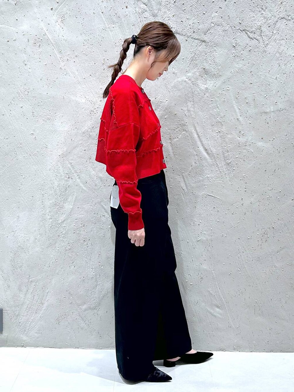 ブラック系のデニムパンツ、ブラック系のパンプス、レッド系のニット/セーターを着用したレディースの秋コーディネートの3枚目の写真