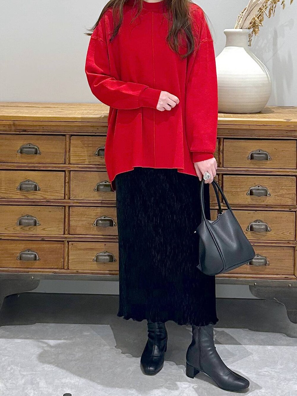 ブラック系のショルダーバッグ、ブラック系のスカート、ブラック系のブーツを着用したレディースの秋コーディネートの3枚目の写真