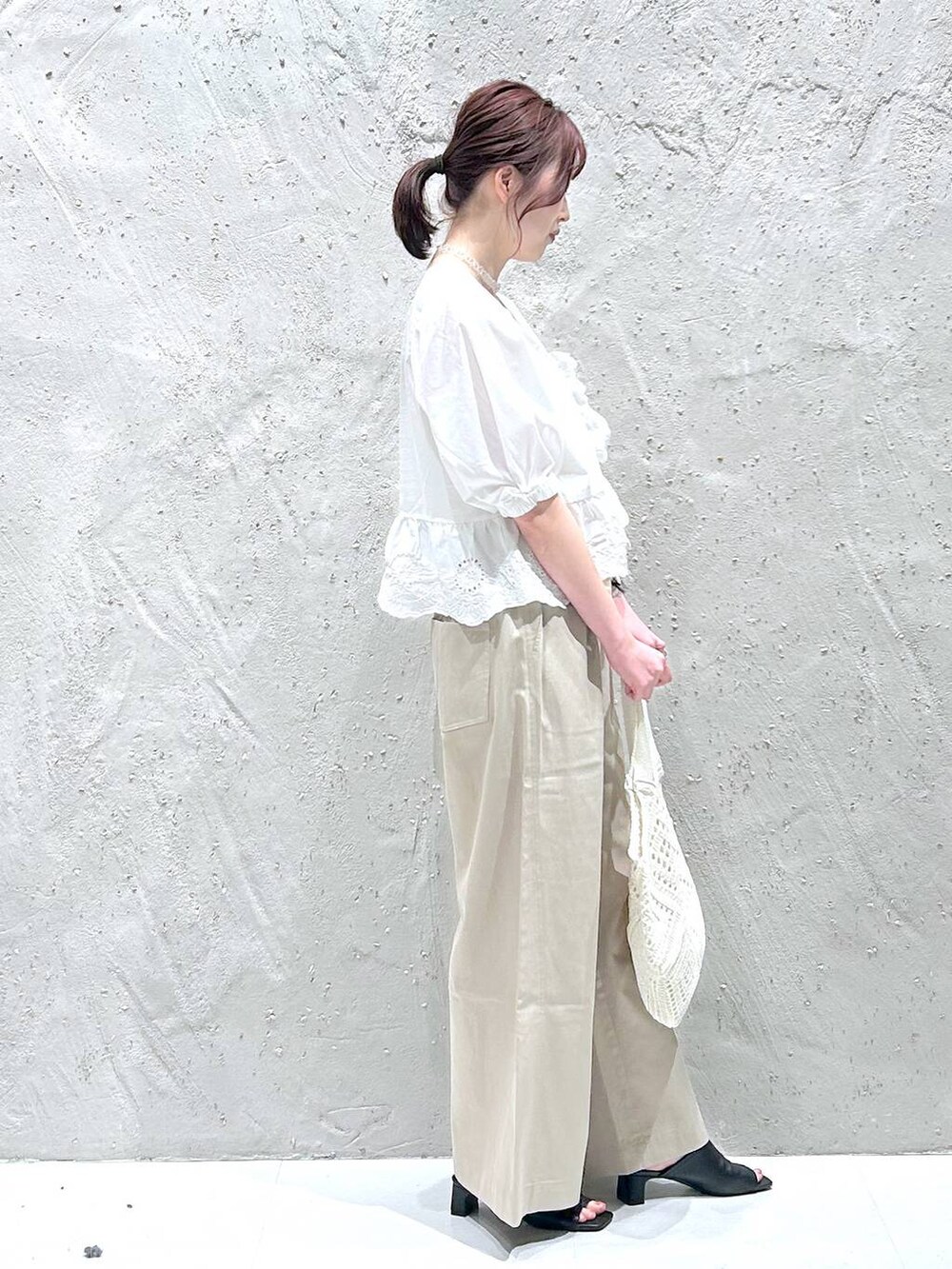 ベージュ系のデニムパンツ、ホワイト系のシャツ/ブラウス、ブラック系のサンダルを着用したレディースの夏コーディネートの2枚目の写真