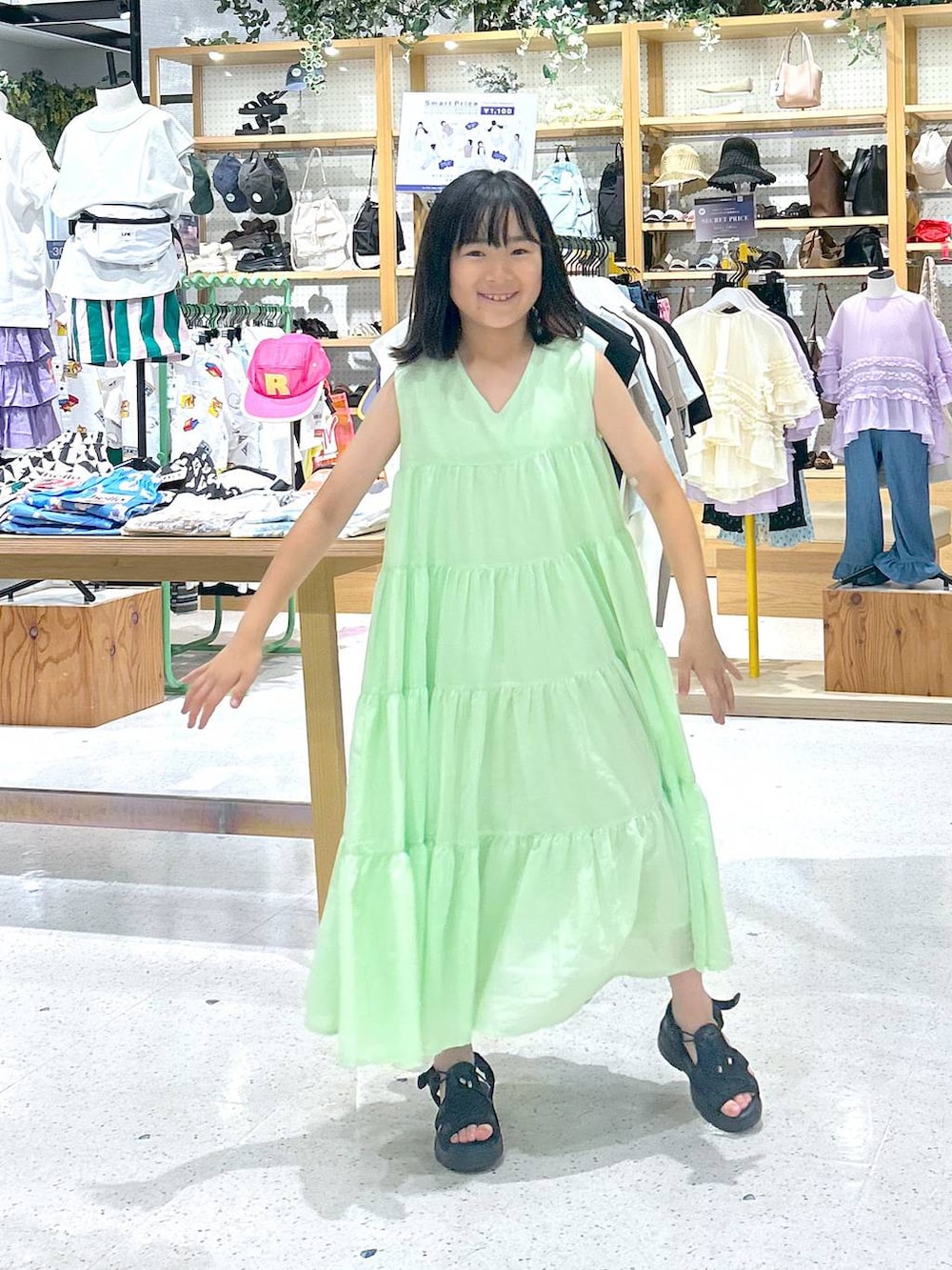 ブラック系のサンダル、グリーン系のワンピースを着用したキッズの夏コーディネートの3枚目の写真