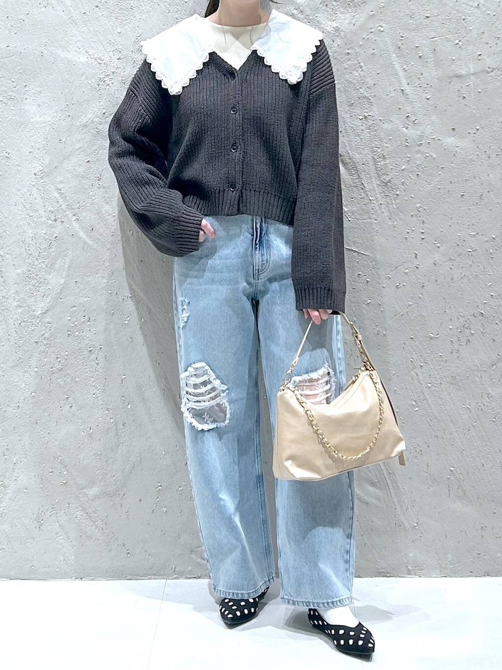 ブルー系のデニムパンツ、ベージュ系のショルダーバッグ、ホワイト系のTシャツ/カットソーを着用したレディースの冬コーディネートの3枚目の写真