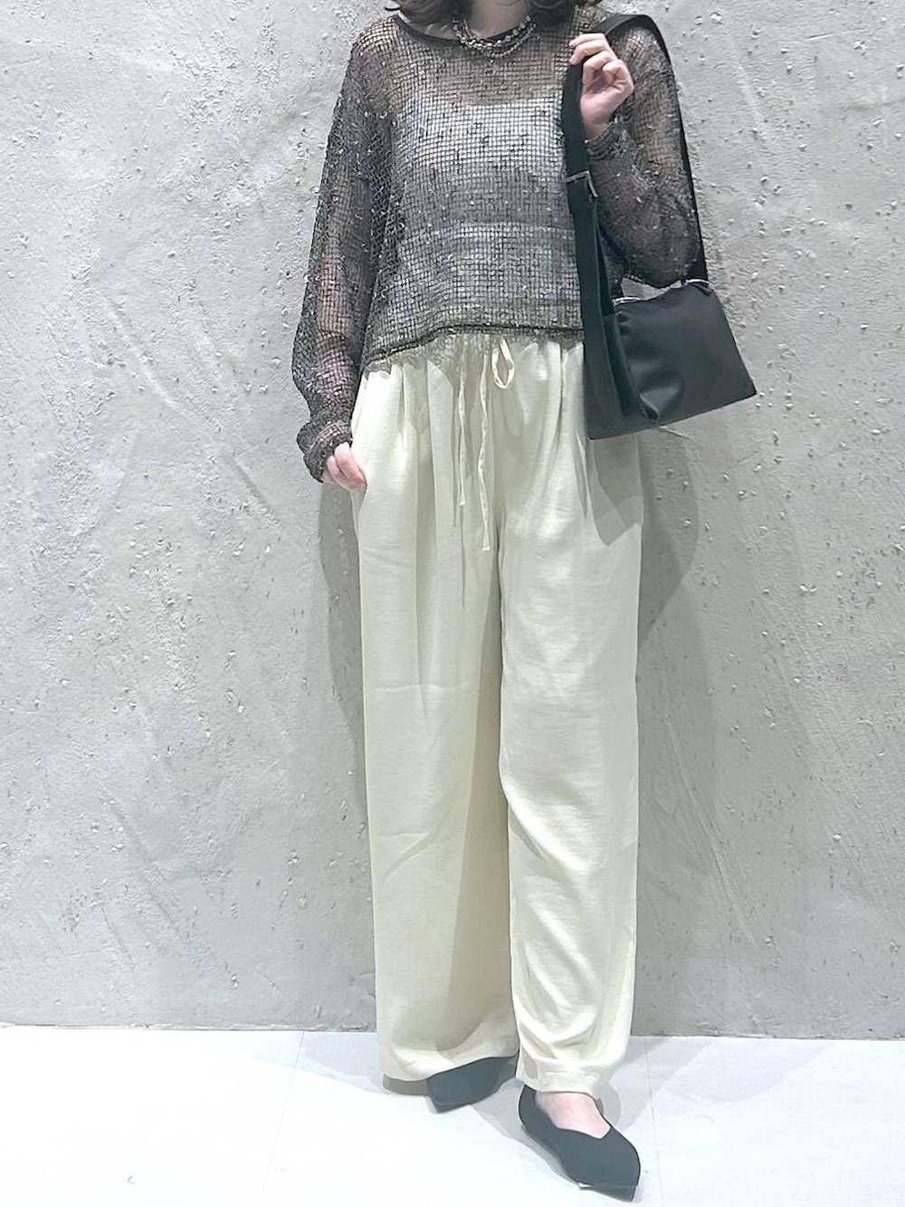 ブラック系のパンプス、イエロー系のその他パンツ、ブラック系のショルダーバッグを着用したレディースの春コーディネートの3枚目の写真