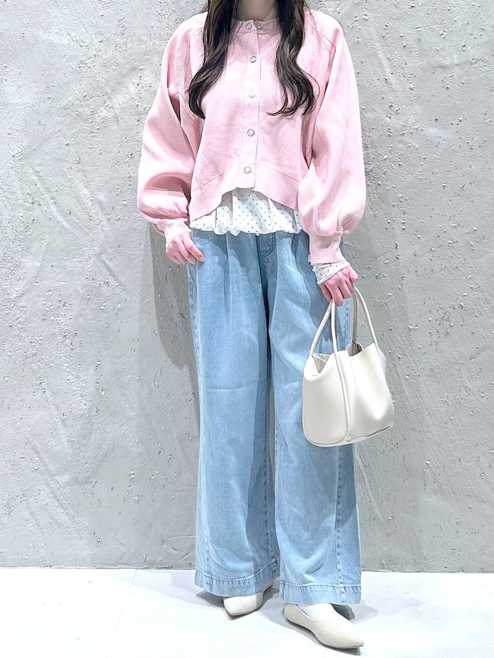 ホワイト系のショルダーバッグ、ブルー系のデニムパンツ、ホワイト系のパンプスを着用したレディースの春コーディネートの3枚目の写真