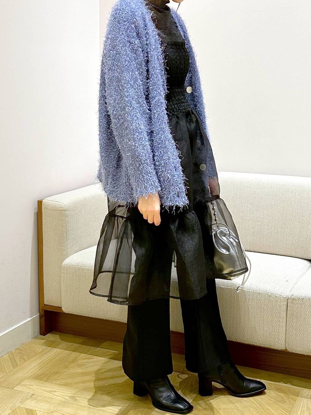 ブラック系のパンプス、ブラック系のスラックス、ブルー系のカーディガン/ボレロを着用したレディースの冬コーディネートの4枚目の写真