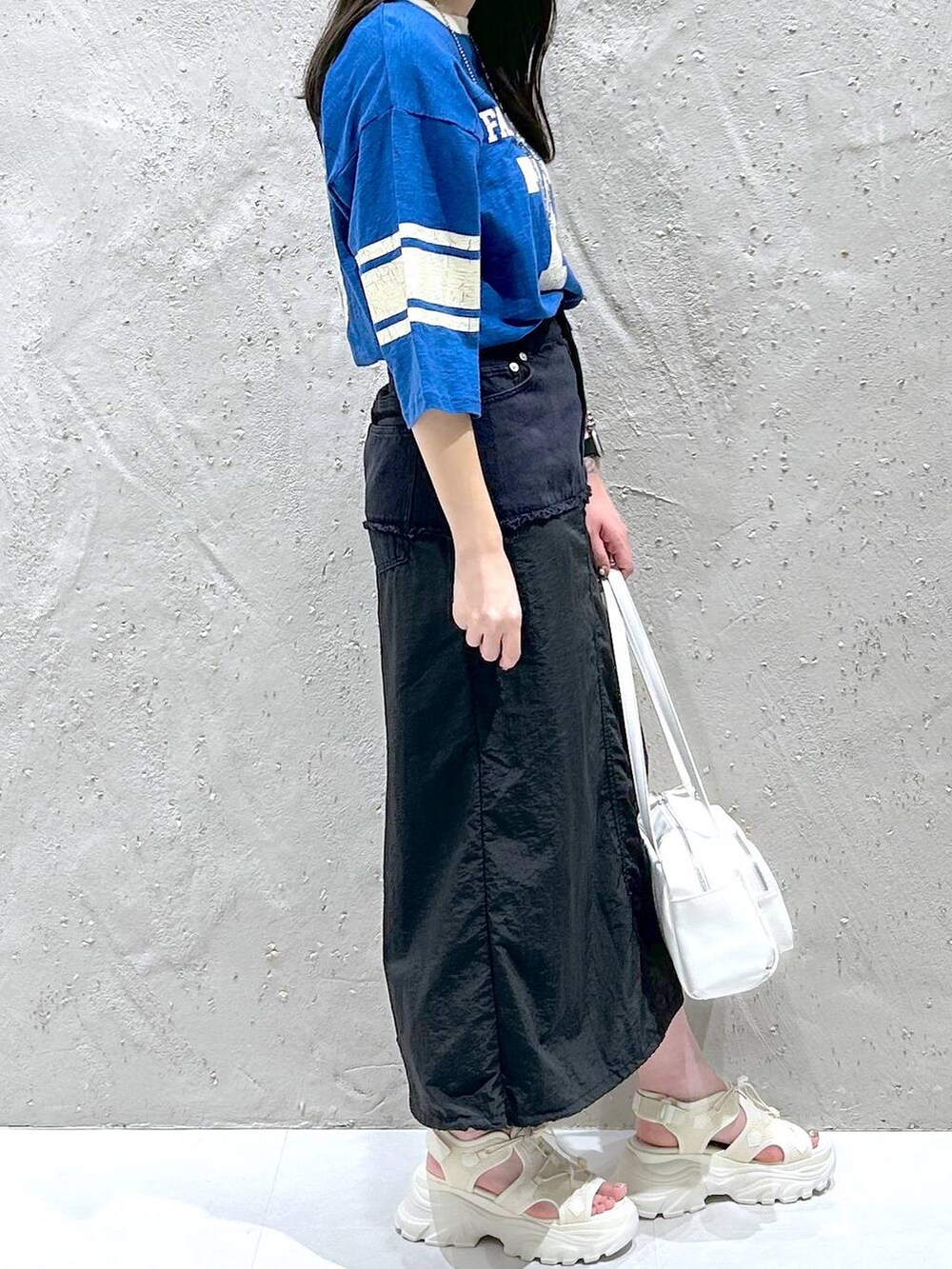 ホワイト系のサンダル、ブラック系のデニムスカート、ホワイト系のボストンバッグを着用したレディースの夏コーディネートの4枚目の写真