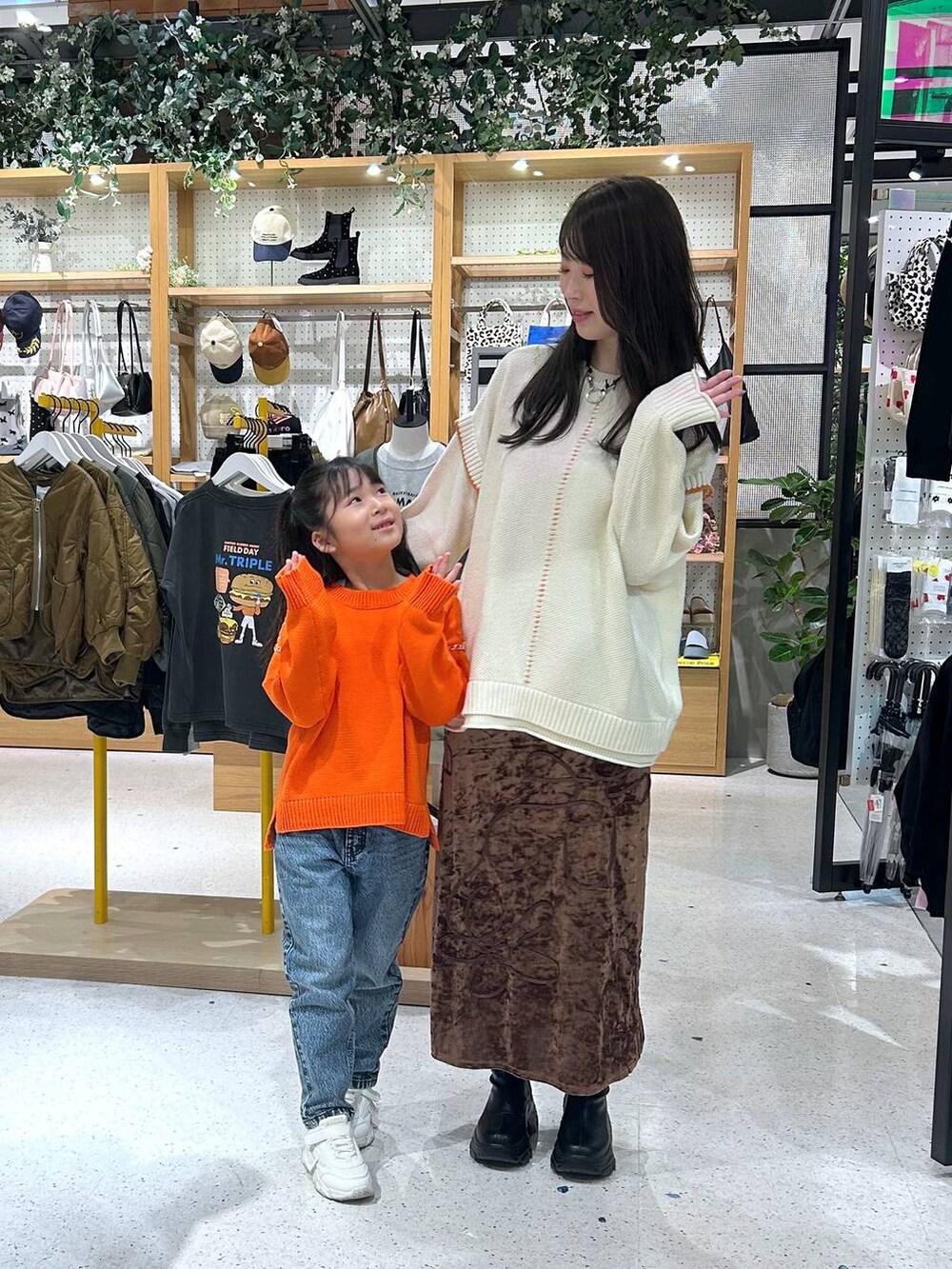 ホワイト系のニット/セーター、ブルー系のデニムパンツ、ブラック系のブーツを着用したレディースの秋コーディネートの2枚目の写真