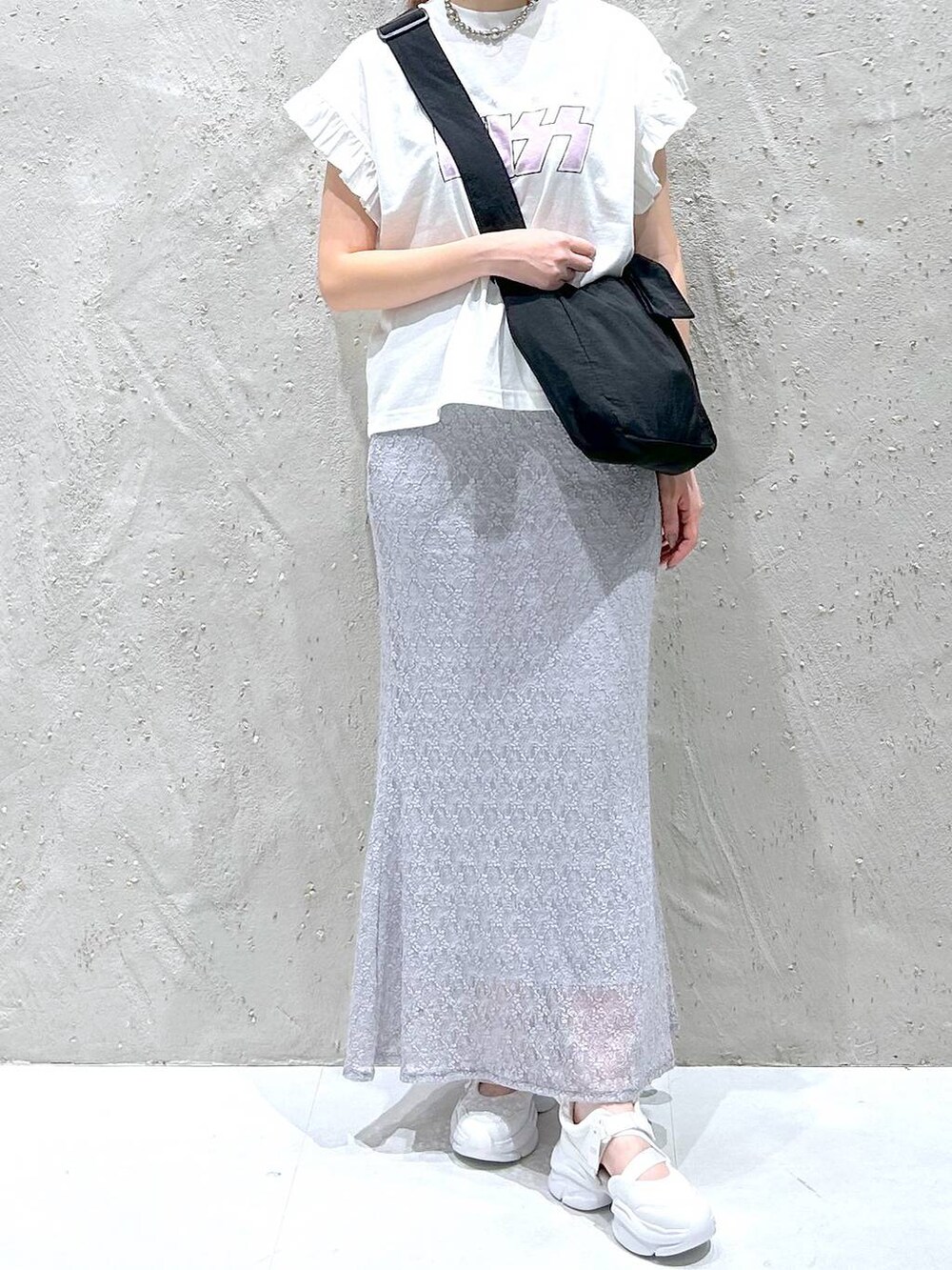 ホワイト系のサンダル、ホワイト系のTシャツ/カットソー、ブラック系のショルダーバッグを着用したレディースの夏コーディネートの2枚目の写真