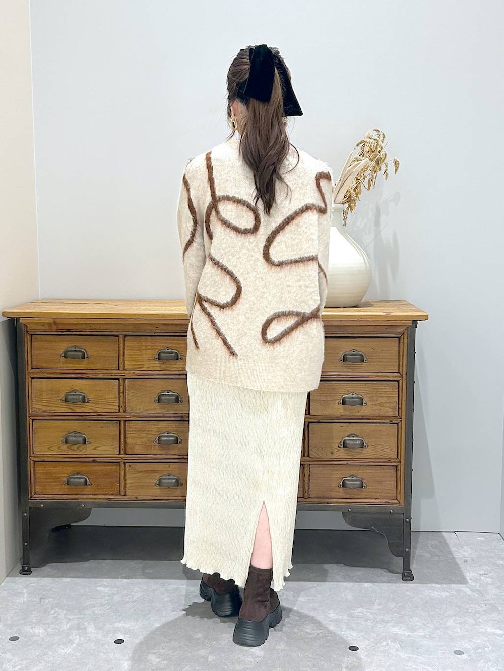 ブラウン系のブーツ、グレー系のショルダーバッグ、ホワイト系のスカートを着用したレディースの秋コーディネートの3枚目の写真