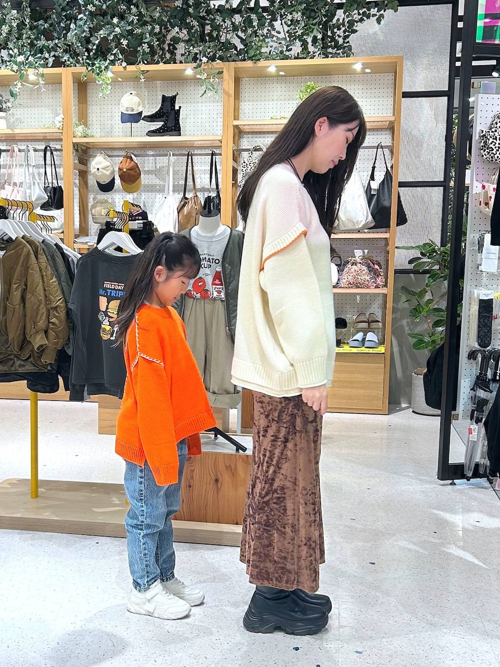 ホワイト系のニット/セーター、ブルー系のデニムパンツ、ブラック系のブーツを着用したレディースの秋コーディネートの3枚目の写真
