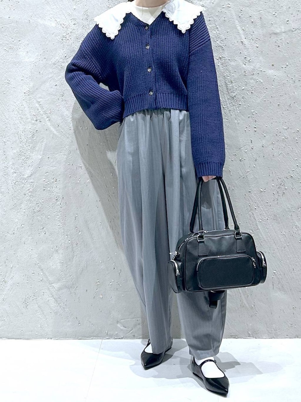 グレー系のその他パンツ、ブラック系のパンプス、ブラック系のボストンバッグを着用したレディースの冬コーディネートの3枚目の写真