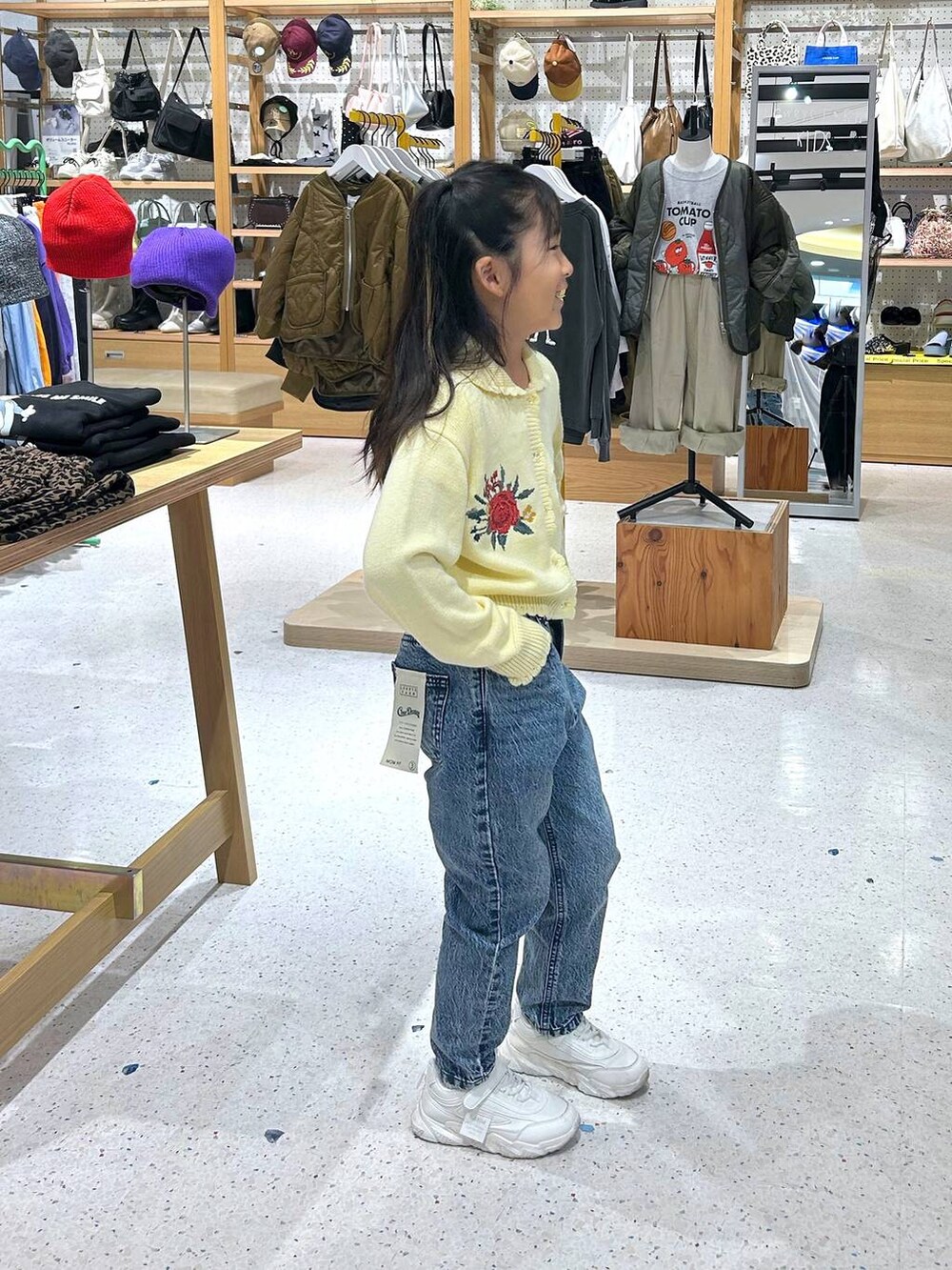 ブルー系のデニムパンツ、ブラック系のカーディガン/ボレロを着用したレディースの秋コーディネートの2枚目の写真