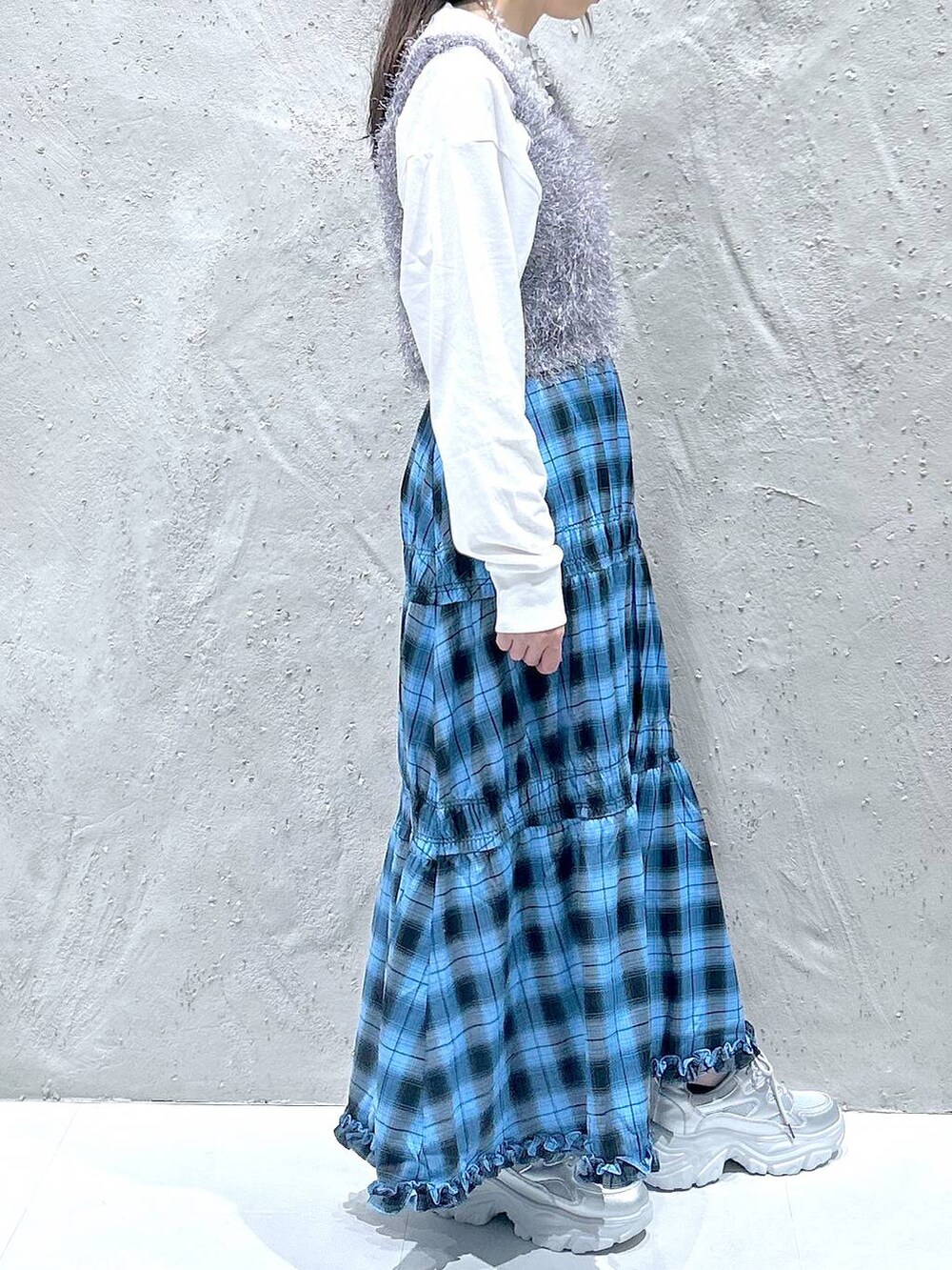 ブルー系のスカート、シルバー系のスニーカー、グレー系のキャミソールを着用したレディースの秋コーディネートの4枚目の写真