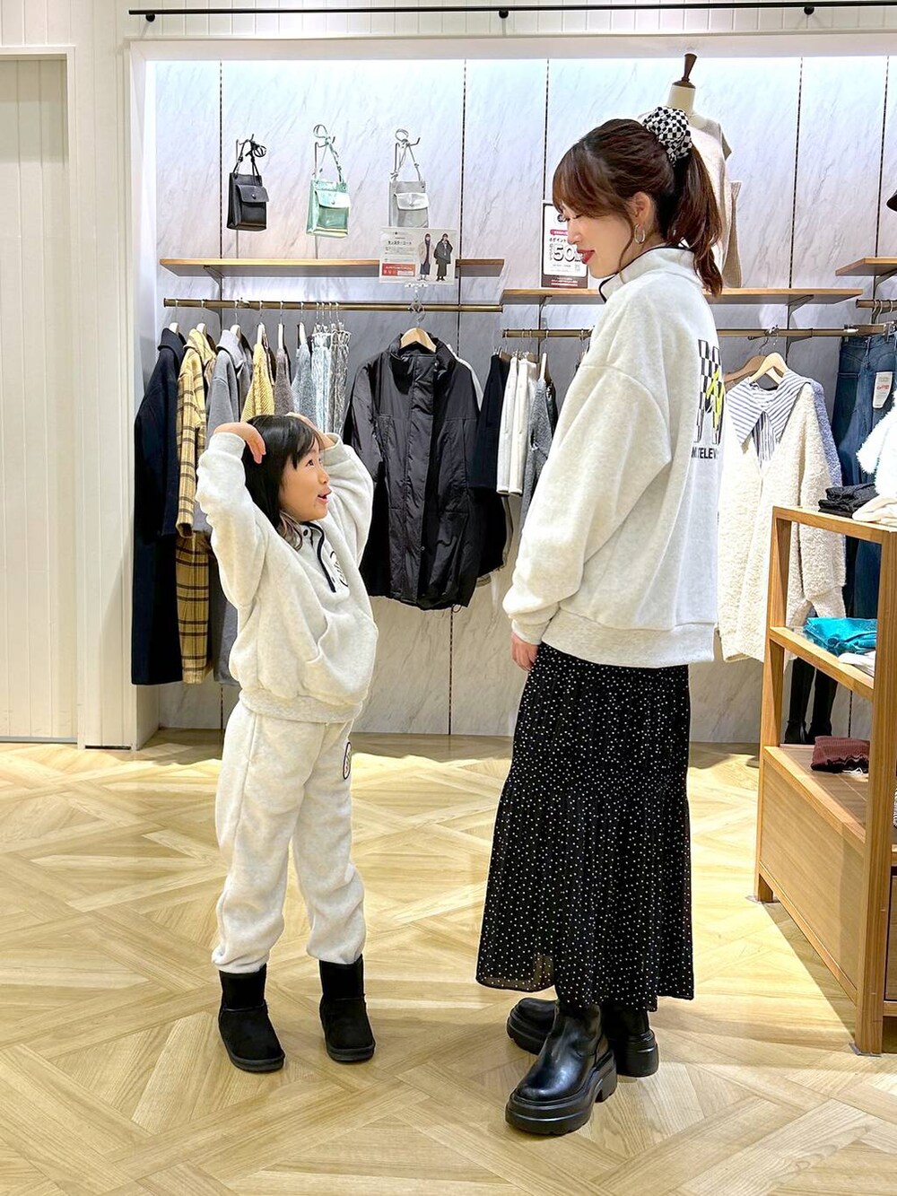 ブラック系のブーツ、ホワイト系のその他パンツ、ホワイト系のパーカーを着用したレディースの秋コーディネートの2枚目の写真