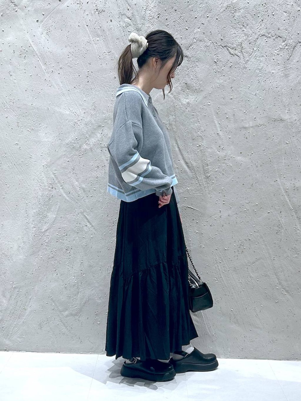 ブラック系のショルダーバッグ、ブラック系のサンダル、ブラック系のスカートを着用したレディースの春コーディネートの2枚目の写真