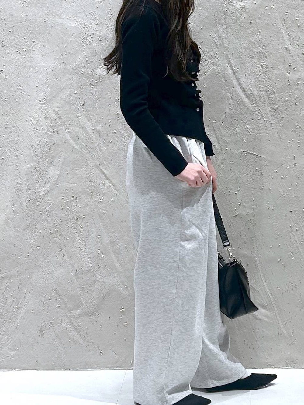 グレー系のスウェットパンツ、ブラック系のショルダーバッグ、ブラック系のパンプスを着用したレディースの春コーディネートの4枚目の写真
