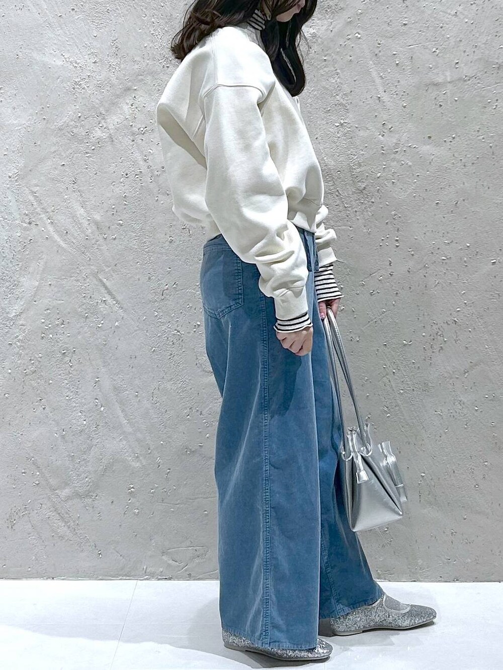 シルバー系のバレエシューズ、シルバー系のショルダーバッグ、ホワイト系のスウェットを着用したレディースの冬コーディネートの4枚目の写真