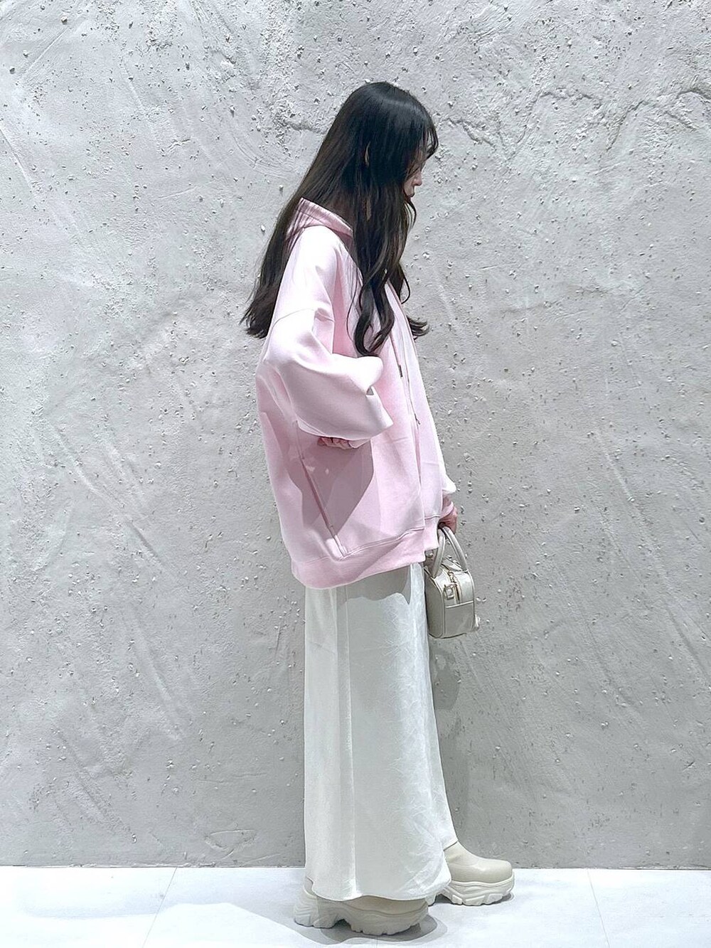 ホワイト系のブーツ、ブラック系のスカート、ピンク系のパーカーを着用したレディースの春コーディネートの2枚目の写真