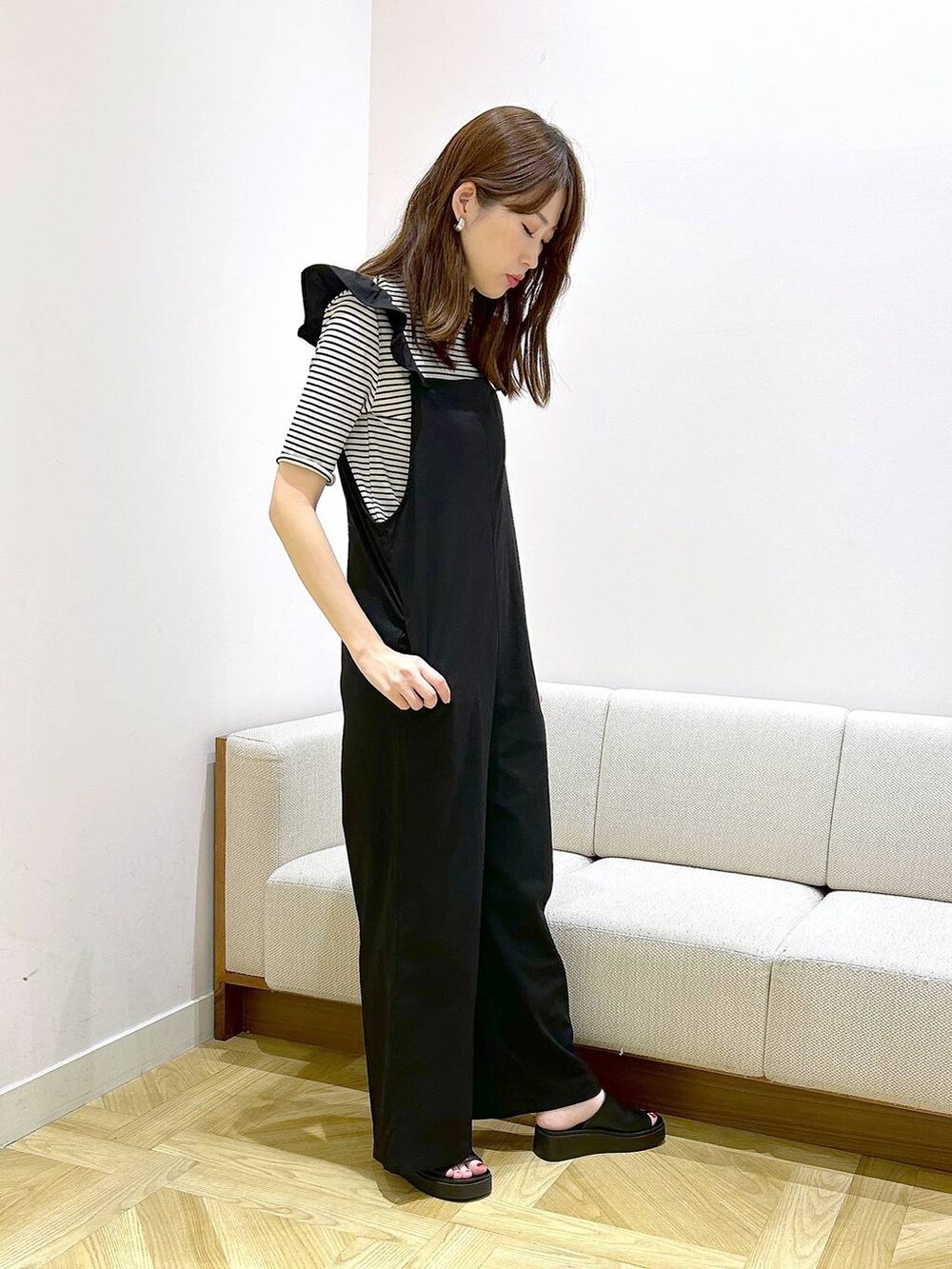 ホワイト系のショルダーバッグ、ブラック系のサンダル、ホワイト系のTシャツ/カットソーを着用したレディースの夏コーディネートの3枚目の写真