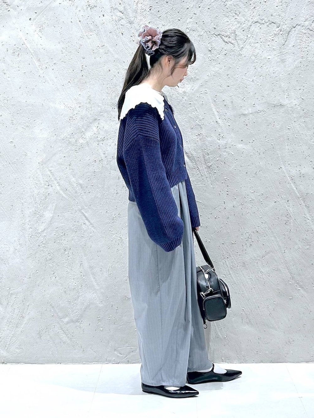 グレー系のその他パンツ、ブラック系のパンプス、ブラック系のボストンバッグを着用したレディースの冬コーディネートの2枚目の写真