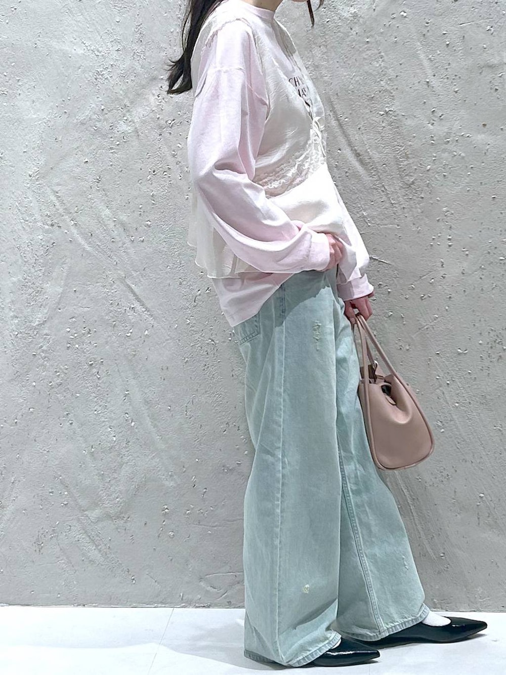 ピンク系のショルダーバッグ、ブラック系のパンプス、ブルー系のデニムパンツを着用したレディースの春コーディネートの4枚目の写真