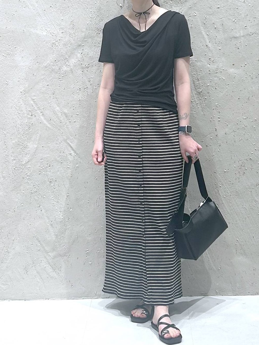 ブラック系のサンダル、ブラック系のTシャツ/カットソー、ブラック系のショルダーバッグを着用したレディースの夏コーディネートの3枚目の写真