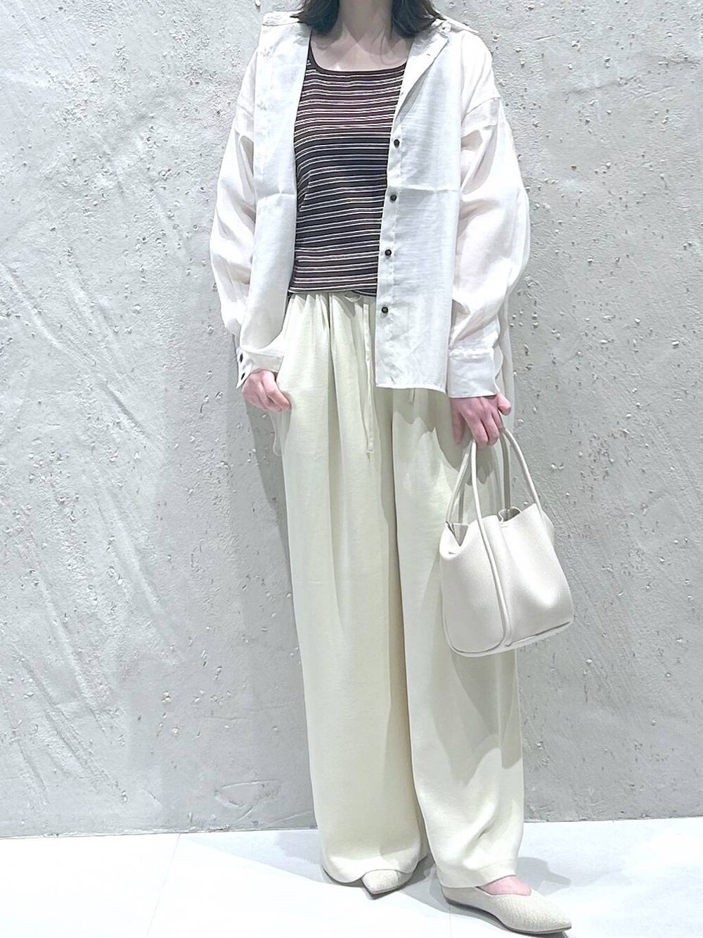 ホワイト系のショルダーバッグ、ホワイト系のシャツ/ブラウス、ホワイト系のパンプスを着用したレディースの春コーディネートの3枚目の写真
