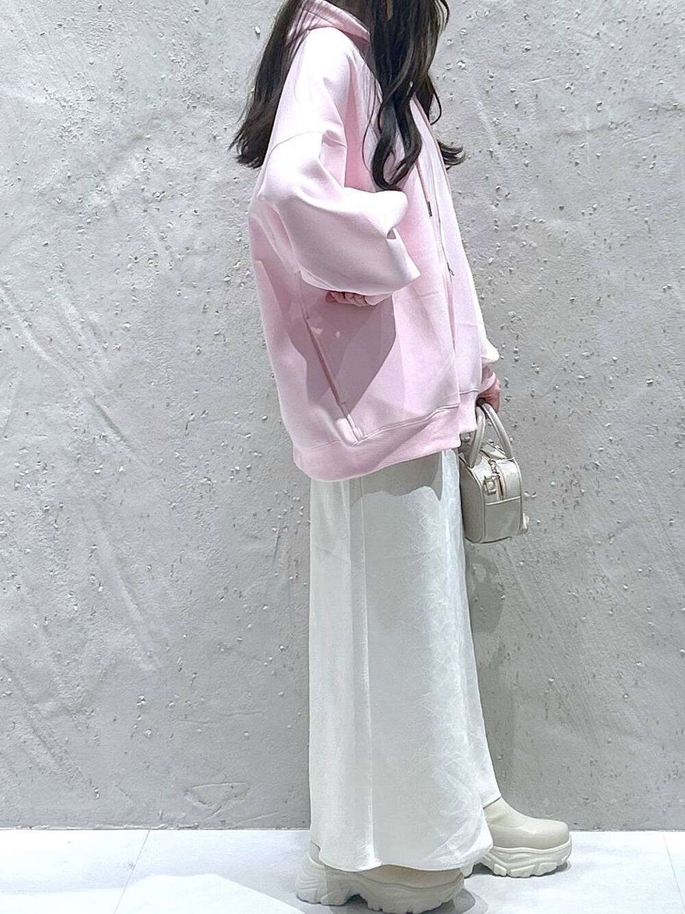 ホワイト系のブーツ、ブラック系のスカート、ピンク系のパーカーを着用したレディースの春コーディネートの4枚目の写真