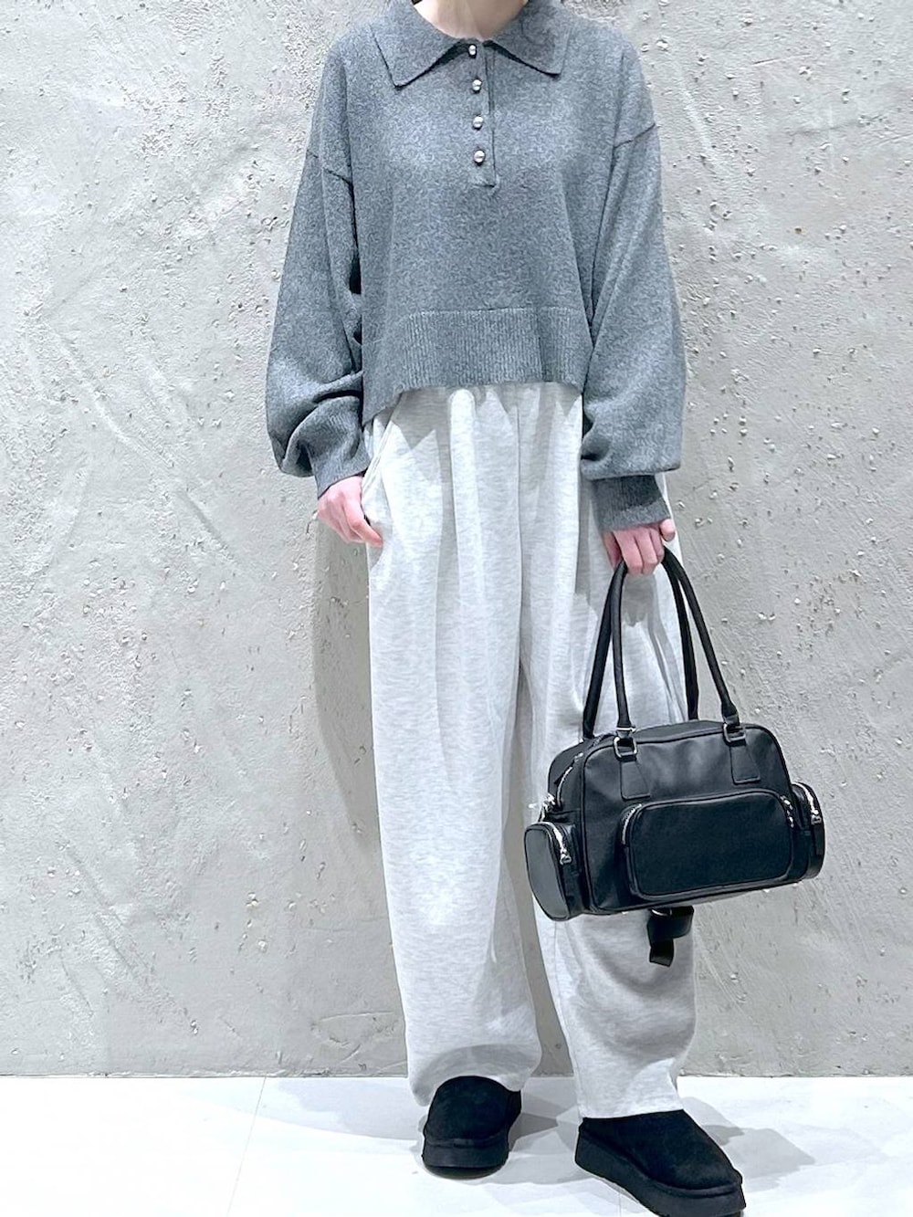グレー系のスウェットパンツ、ブラック系のブーツ、ブラック系のボストンバッグを着用したレディースの冬コーディネートの3枚目の写真