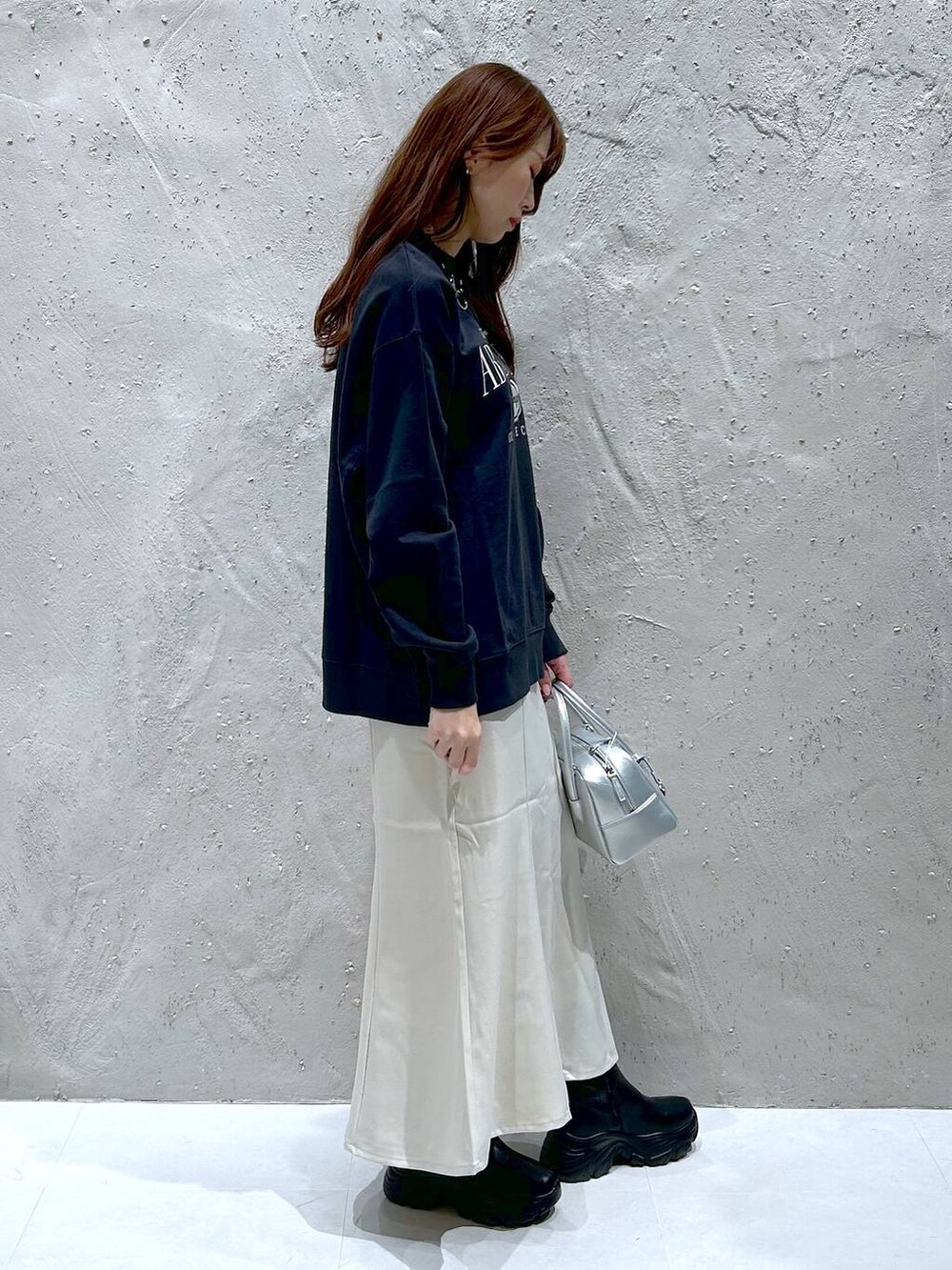 ブラック系のブーツ、シルバー系のボストンバッグ、グレー系のスウェットを着用したレディースの秋コーディネートの3枚目の写真