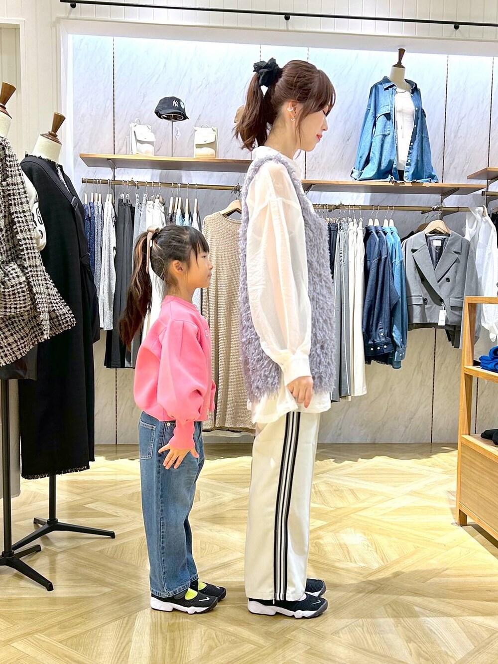 ブルー系のデニムパンツ、ホワイト系のシャツ/ブラウス、ピンク系のカーディガン/ボレロを着用したレディースの秋コーディネートの2枚目の写真