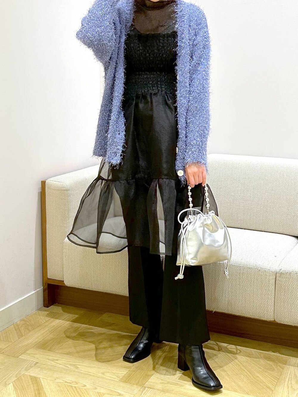 ブラック系のパンプス、ブラック系のスラックス、ブルー系のカーディガン/ボレロを着用したレディースの冬コーディネートの2枚目の写真