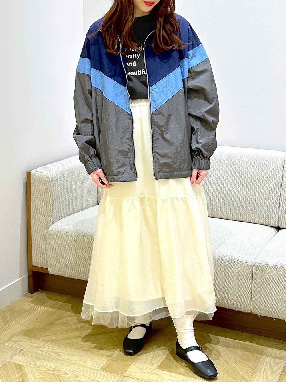 ブラック系のパンプス、ホワイト系のスカート、グレー系のTシャツ/カットソーを着用したレディースの春コーディネートの2枚目の写真