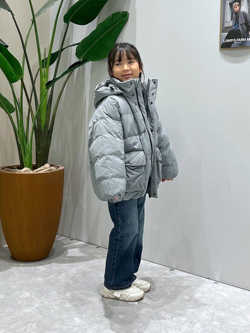 ブルー系のダウンジャケット/コート、ブルー系のデニムパンツ、ブルー系のニット/セーターを着用したキッズの冬コーディネートの2枚目の写真