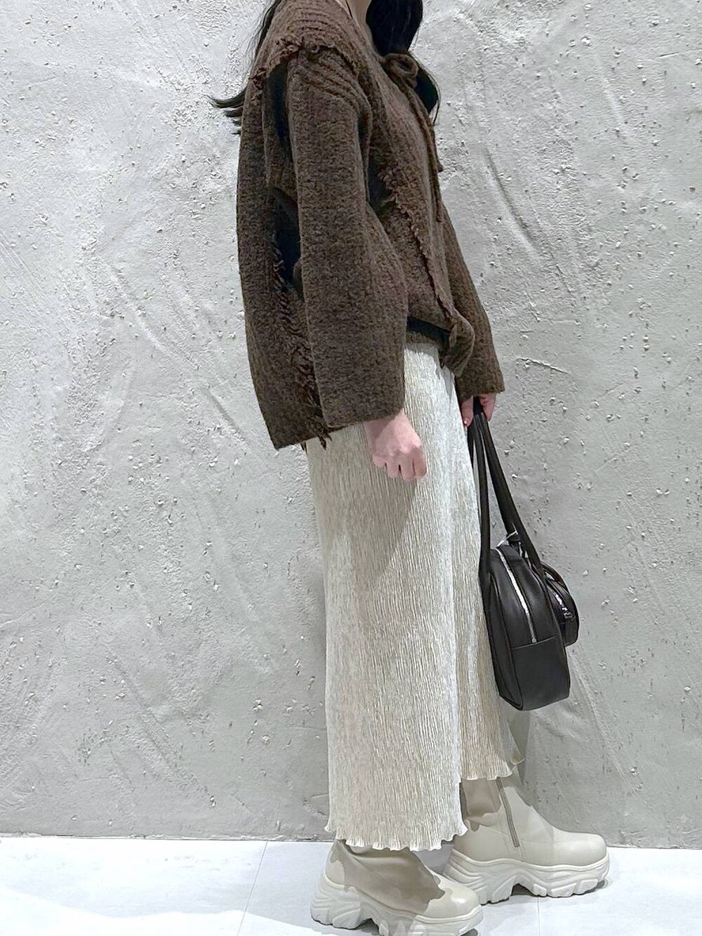 ブラウン系のニット/セーター、ホワイト系のブーツ、ホワイト系のスカートを着用したレディースの冬コーディネートの4枚目の写真