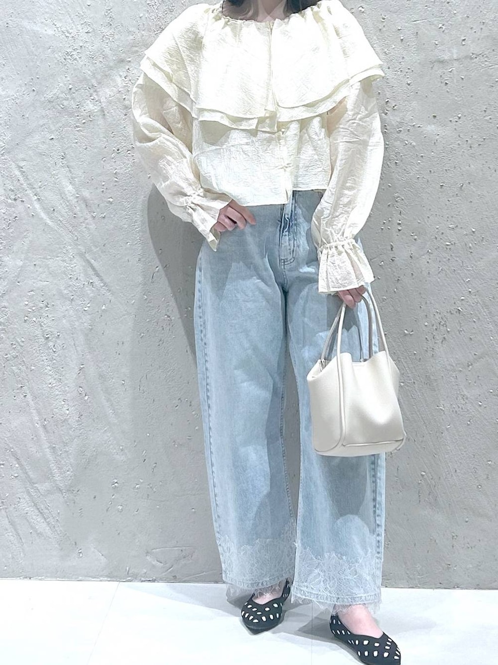 ホワイト系のショルダーバッグ、ブルー系のデニムパンツ、その他のパンプスを着用したレディースの春コーディネートの3枚目の写真
