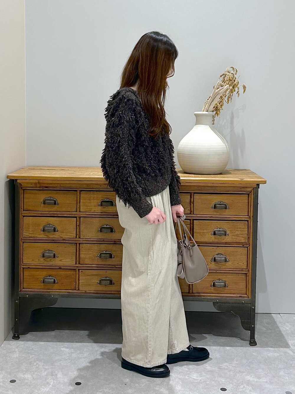 ホワイト系のその他パンツ、グレー系のショルダーバッグ、ブラック系のローファーを着用したレディースの秋コーディネートの2枚目の写真