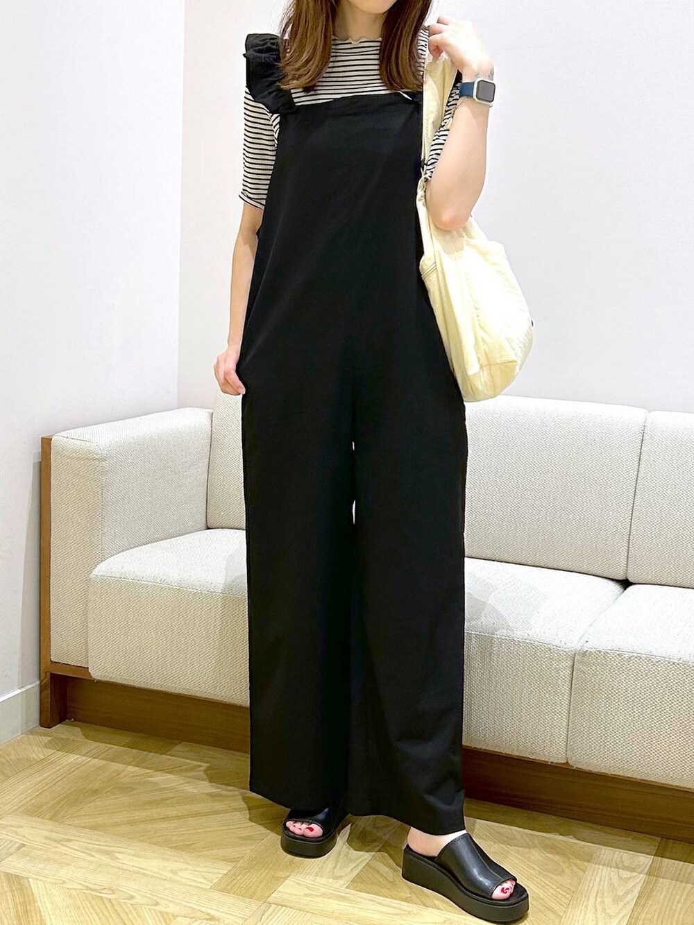 ホワイト系のショルダーバッグ、ブラック系のサンダル、ホワイト系のTシャツ/カットソーを着用したレディースの夏コーディネートの2枚目の写真