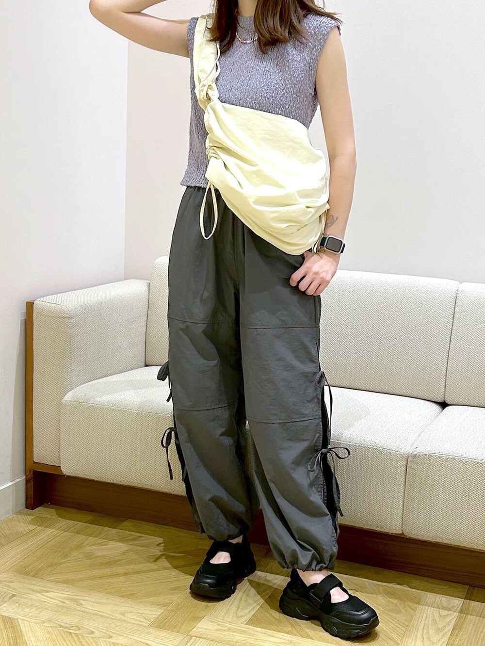 ブラック系のサンダル、グレー系のその他パンツ、ホワイト系のショルダーバッグを着用したレディースの夏コーディネートの2枚目の写真