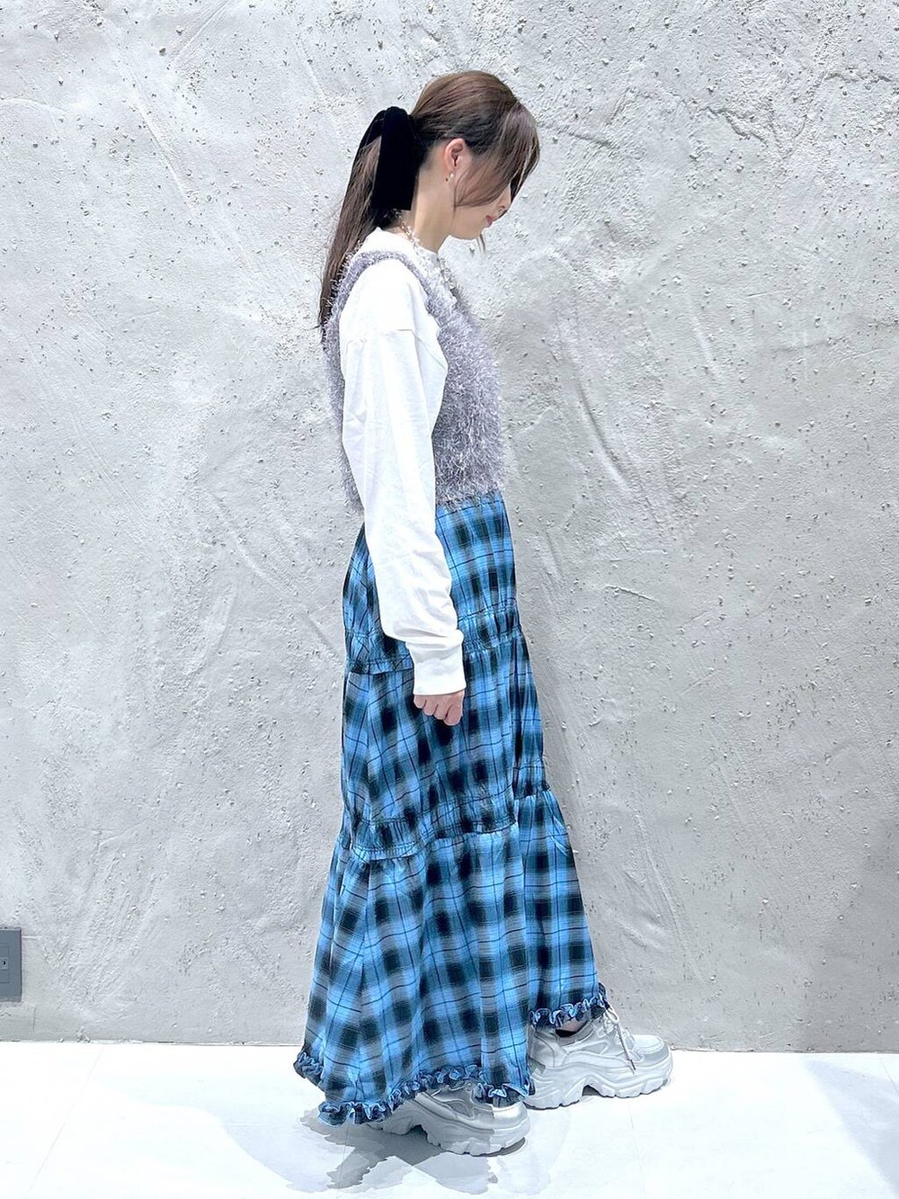 ブルー系のスカート、シルバー系のスニーカー、グレー系のキャミソールを着用したレディースの秋コーディネートの3枚目の写真